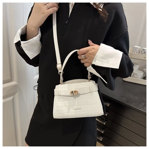 Detail showing white crocodile pattern leather texture and golden twist lock closure