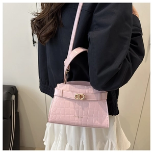 Detail of pink croc-effect mini bag featuring a gold-tone rotating metal clasp and handle