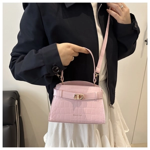 Detail of pink faux leather bag featuring crocodile texture and interlocking metal CD clasp
