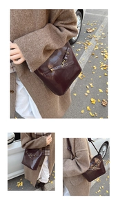Detail of burgundy leather bucket bag with metallic grommets in autumn street setting