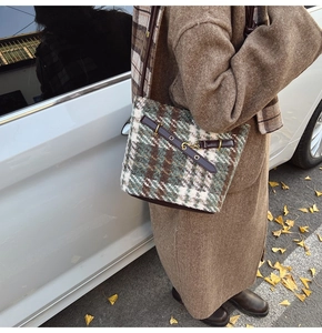 Detailed plaid wool bucket bag with leather strap and metal clasp in autumn style