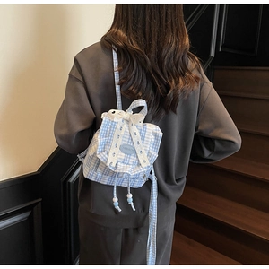 Detail showing blue plaid backpack with lace trim and bowknot on model back