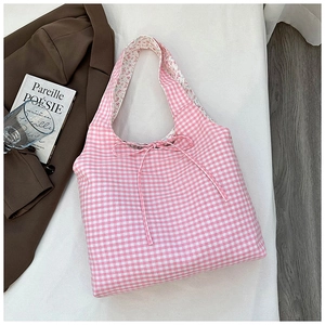 Close-up of pink gingham tote bag featuring a decorative bow and floral print lining