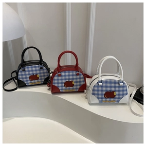 Three colorful square handbags with apple prints and check patterns on white stands