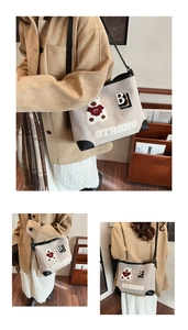 Dettaglio della borsa tote in tela beige con ricamo orso e angoli in pelle nera