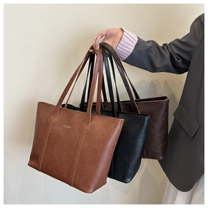 Three leather tote bags in brown, black and coffee colors with long shoulder handles
