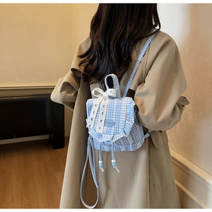 Detailed view of gingham mini backpack with white lace bow and ruffle edge design