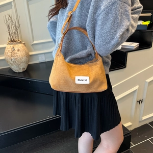 Vintage orange suede dumpling bag with crossbody strap and urban streetwear patch