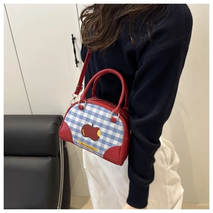 Detail of red apple pattern on blue and white checkered canvas bowling handbag