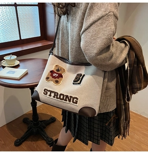 Dettaglio della borsa tote in tela con ricamo a orsetto e design patchwork con lettere