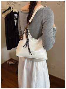 Detail view of white PU leather shoulder bag with textured rope and wooden charm