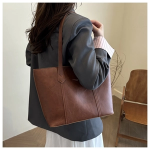 Detail of brown tote bag made of high-quality synthetic leather with decorative stitching