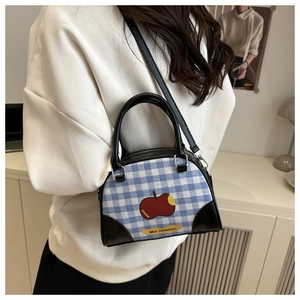 Detail of blue and white checkered bowling bag with apple print and black leather straps