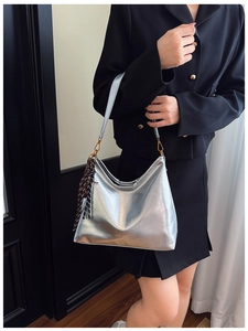 Close-up of metallic silver hobo bag with gold hardware and geometric scarf detail