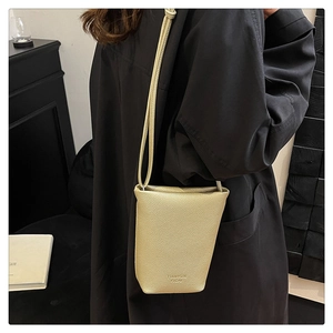 Detail of champagne gold mini bucket bag showing fine lychee grain texture and logo