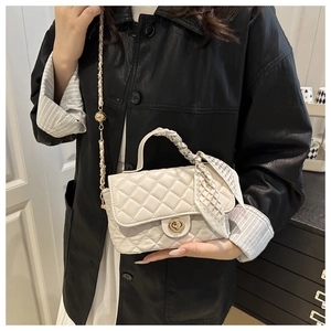 Quilted cream crossbody bag featuring a silk scarf handle and elegant metal chain strap