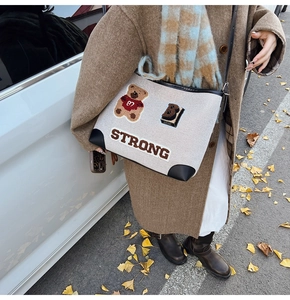 Dettaglio della borsa tote in tela con ricamo a forma di orso e finiture in pelle in autunno