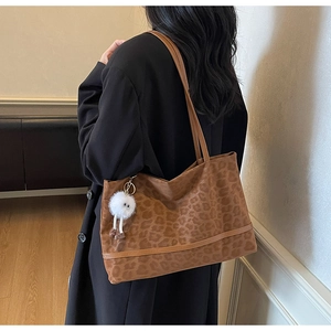 Dettaglio borsa shopper leopardata con spalline marroni e ciondolo di peluche con occhi