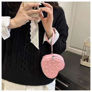 Detailed shot of a pink heart-shaped mini handbag with 3D embossed hearts and metal zipper