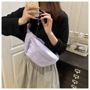 Detailed close-up of light purple corduroy waist bag with woven zipper puller