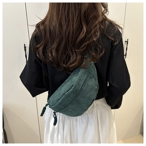 Detail of dark green corduroy crescent crossbody bag showing soft ribbed texture