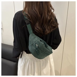 Detail of dark green corduroy crossbody bag with adjustable strap and textured stripe fabric