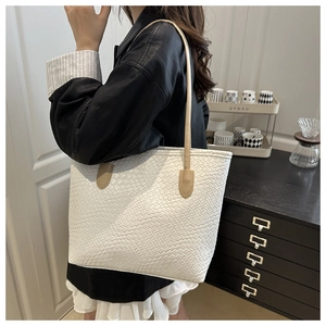 Detail of white woven tote bag texture with slim leather shoulder straps for daily use