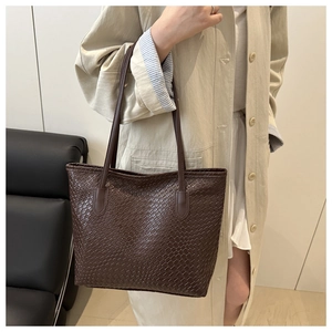 Close-up of deep brown woven texture on a large capacity tote bag with shoulder straps