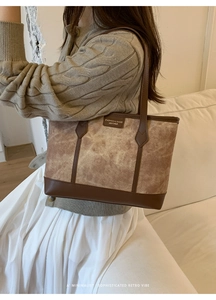 Close-up of retro marble texture tote bag with brown leather contrast and stitching details