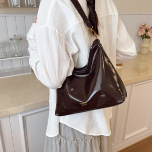 Deep coffee brown glossy leather crescent tote bag with fashion lettering and gold hardware