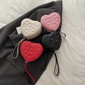Mini-handtassen in hartvorm in wit, roze, zwart en rood met harttexturen in reliëf