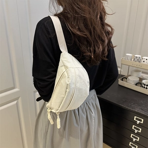 Beige corduroy crossbody chest bag with striped texture and woven knot zip detail