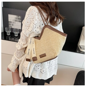 Close-up of contrast trim woven tote bag with ribbon detail and leather handles