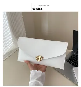 Détail de la pochette enveloppe blanche avec boucle métallique dorée à vagues