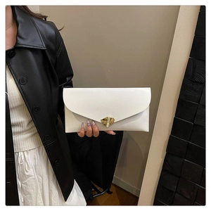 Détail de la pochette de soirée blanche en cuir avec boucle triangulaire dorée