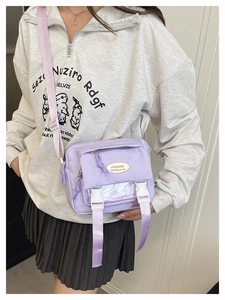 Lavender nylon crossbody bag detail with buckle strap and zipper pocket on model