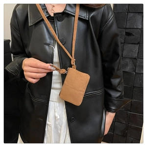 Brown faux suede neck pouch mini coin bag detail on female model with leather jacket