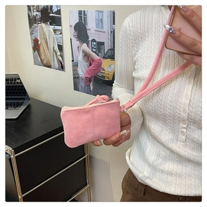 Pink suede mini coin purse with lanyard strap shown held in hand for lifestyle use