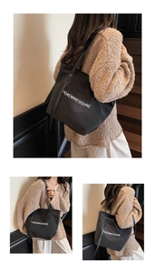 Détails du sac cabas minimaliste en toile noire avec lettrage blanc et bandoulières longues