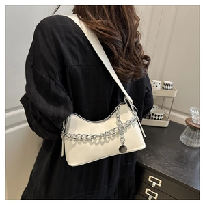 White leather hobo bag with silver chain worn by a model in a minimalist style