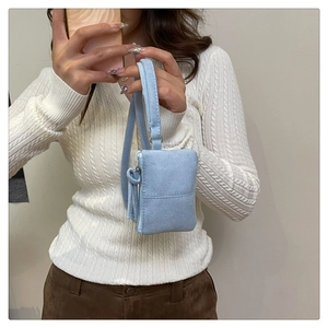 Detail of light blue faux suede square mini bag with side zipper and slim strap