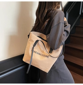 Détail du sac cabas en toile avec texte FCAEMINESGUNE et bandoulières contrastées