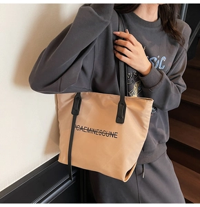 Sac fourre-tout en nylon kaki avec anses noires et imprimé porté par un mannequin
