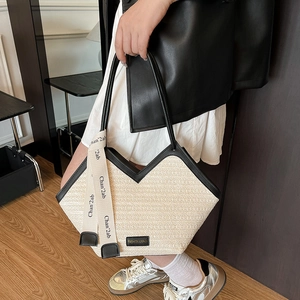 Contrast woven straw tote bag with black leather trim and elegant ribbon handle