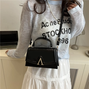 Borsa a mano nera lucida con chiusura a V dorata e tracolla per donna