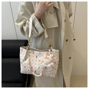 Détail du sac cabas floral avec breloque lapin en peluche et chaîne en perles