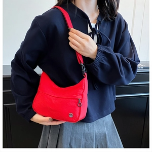 Detail view of red waterproof crossbody bag featuring front zipper and adjustable strap
