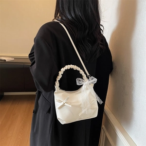 Creamy white bow shoulder bag with pleat handle in a ballet-inspired aesthetic