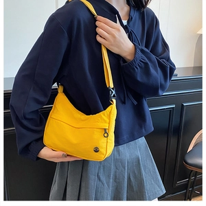 Detail of waterproof nylon crossbody bag in bright yellow with adjustable shoulder strap