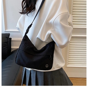 Detail of waterproof nylon dumpling bag with adjustable strap and side zipper pocket